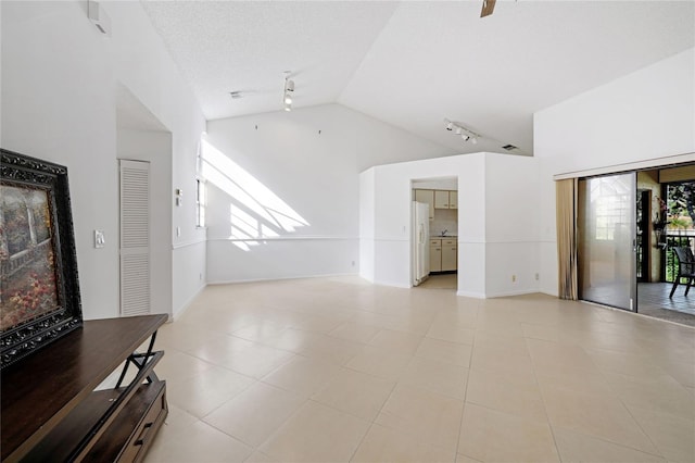 17340 Boca Club Blvd Unit 703, Boca Raton, FL 33487 - unfurnished living room featuring vaulted ceiling, track lighting, and light tile patterned floors