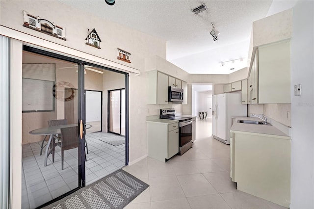 17340 Boca Club Blvd Unit 703, Boca Raton, FL 33487 - kitchen featuring stainless steel appliances, light countertops, track lighting, a textured ceiling, and light tile patterned floors