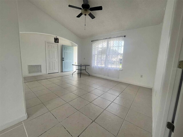 343 Marquee Dr, Kissimmee, FL 34758 - empty room featuring a textured ceiling, light tile patterned floors, lofted ceiling, ceiling fan, and arched walkways