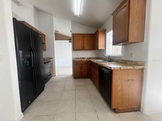 343 Marquee Dr, Kissimmee, FL 34758 - kitchen featuring black appliances, vaulted ceiling, brown cabinetry, light tile patterned floors, and light countertops