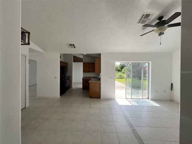 343 Marquee Dr, Kissimmee, FL 34758 - unfurnished living room featuring a textured ceiling, ceiling fan, and light tile patterned flooring