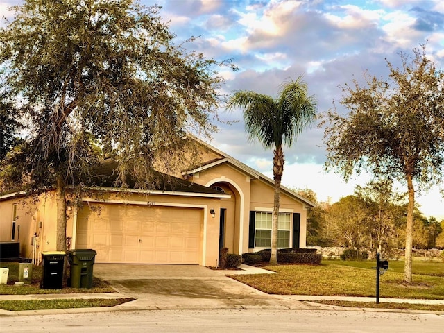 2281 Royal Ridge Dr, Davenport, FL 33896 - ranch-style house with an attached garage, driveway, stucco siding, and a front yard