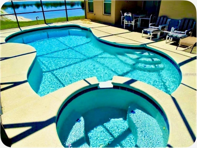2281 Royal Ridge Dr, Davenport, FL 33896 - view of swimming pool featuring a patio, a pool with connected hot tub, a lanai, and a water view