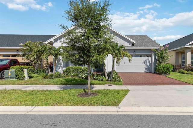2772 Southland St, Saint Cloud, FL 34772 - view of property hidden behind natural elements with decorative driveway, a garage, a front yard, and stucco siding