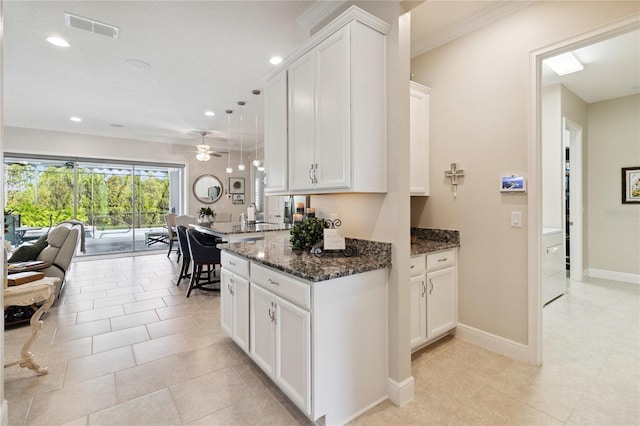 2772 Southland St, Saint Cloud, FL 34772 - kitchen with white cabinets, dark stone countertops, ceiling fan, recessed lighting, and light tile patterned flooring