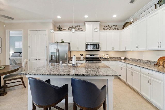 2772 Southland St, Saint Cloud, FL 34772 - kitchen featuring appliances with stainless steel finishes, ornamental molding, a kitchen breakfast bar, a kitchen island with sink, and light stone countertops