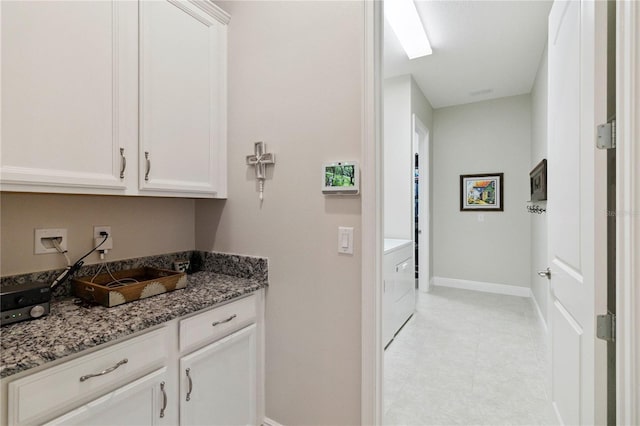 2772 Southland St, Saint Cloud, FL 34772 - kitchen with white cabinetry, stone countertops, and washer / clothes dryer