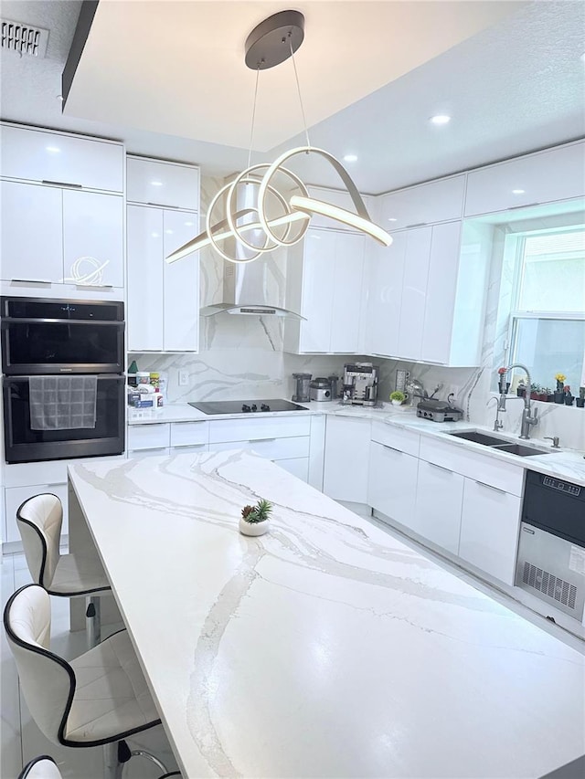 2805 Carter Grove Ln, Kissimmee, FL 34741 - kitchen with modern cabinets, white cabinets, black appliances, light stone countertops, and a kitchen breakfast bar