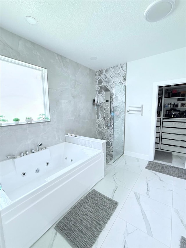 2805 Carter Grove Ln, Kissimmee, FL 34741 - bathroom with marble look tiles, a jetted tub, a textured ceiling, a walk in shower, and a walk in closet