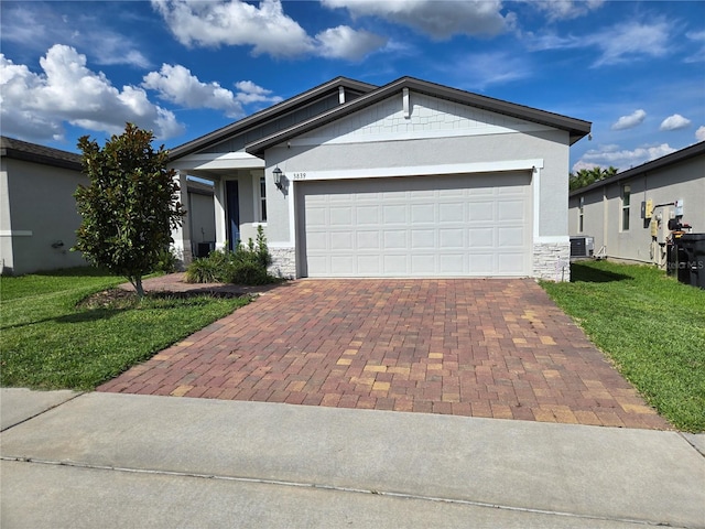 3839 Marbella Way, Davenport, FL 33897 - single story home featuring stone siding, stucco siding, decorative driveway, a front yard, and a garage
