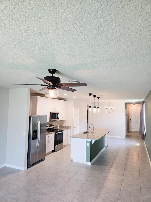3839 Marbella Way, Davenport, FL 33897 - kitchen with stainless steel appliances, ceiling fan, white cabinetry, light stone counters, and a kitchen island with sink