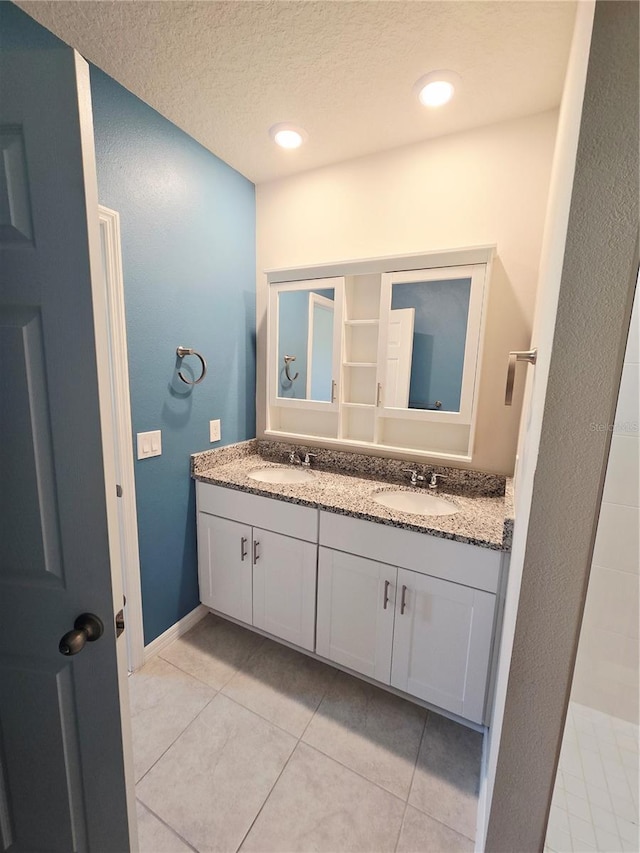 3839 Marbella Way, Davenport, FL 33897 - bathroom with double vanity, tile patterned floors, and a textured ceiling