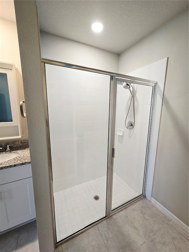 3839 Marbella Way, Davenport, FL 33897 - full bath featuring a stall shower, vanity, tile patterned flooring, and a textured ceiling