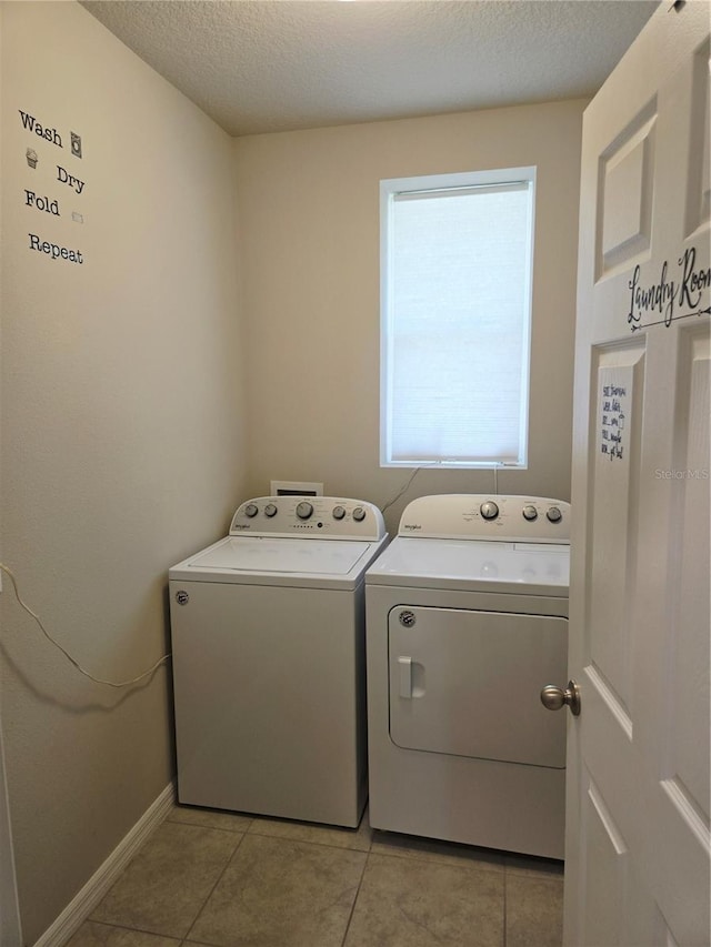3839 Marbella Way, Davenport, FL 33897 - washroom with washing machine and clothes dryer, light tile patterned flooring, and a textured ceiling