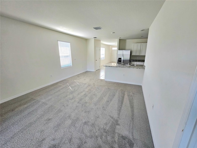 1370 Holodak Dr, Davenport, FL 33837 - unfurnished living room featuring baseboards and light carpet