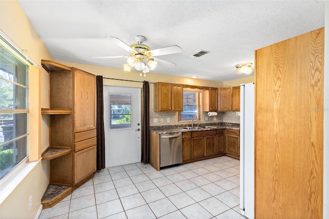 1101 Oregon Ave, Saint Cloud, FL 34769 - kitchen with dishwasher, freestanding refrigerator, brown cabinetry, a ceiling fan, and light tile patterned floors