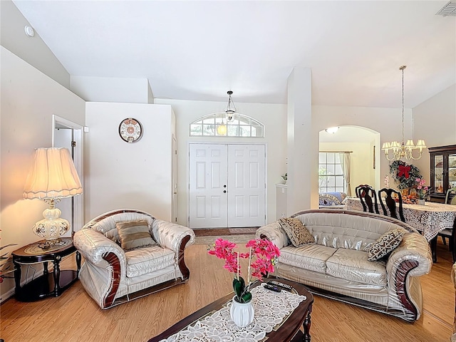 3158 Forest Breeze Way, Saint Cloud, FL 34771 - living room featuring a chandelier, arched walkways, wood finished floors, and vaulted ceiling