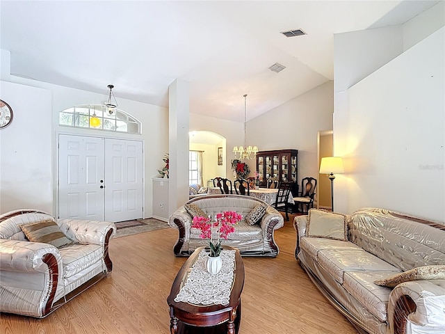 3158 Forest Breeze Way, Saint Cloud, FL 34771 - living area with a chandelier, light wood finished floors, vaulted ceiling, and arched walkways