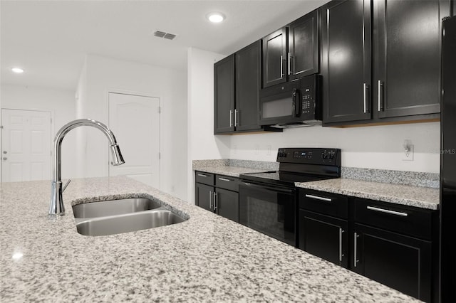 371 Pinecrest Loop, Davenport, FL 33837 - kitchen featuring black appliances, dark cabinetry, recessed lighting, and light stone countertops