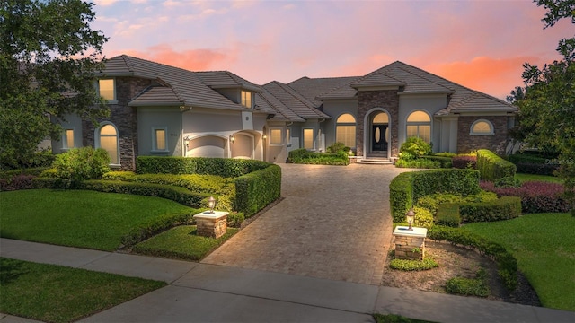 9905 Lanai View Ct, Windermere, FL 34786 - view of front facade featuring decorative driveway, stucco siding, a front yard, and stone siding