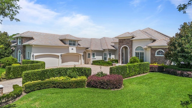 9905 Lanai View Ct, Windermere, FL 34786 - mediterranean / spanish-style house with stucco siding, a front lawn, and stone siding