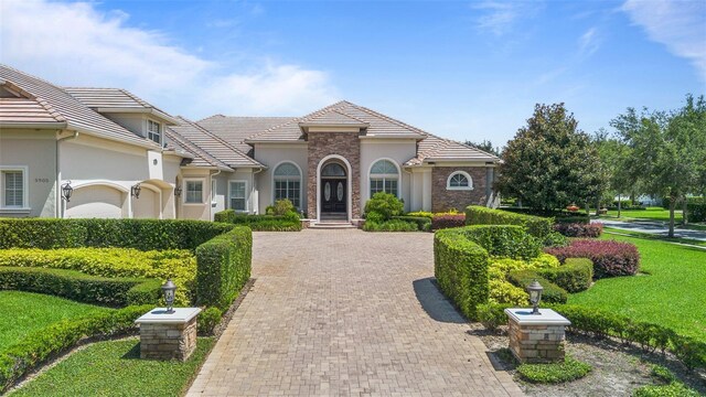 9905 Lanai View Ct, Windermere, FL 34786 - mediterranean / spanish house with stucco siding, decorative driveway, and a tile roof