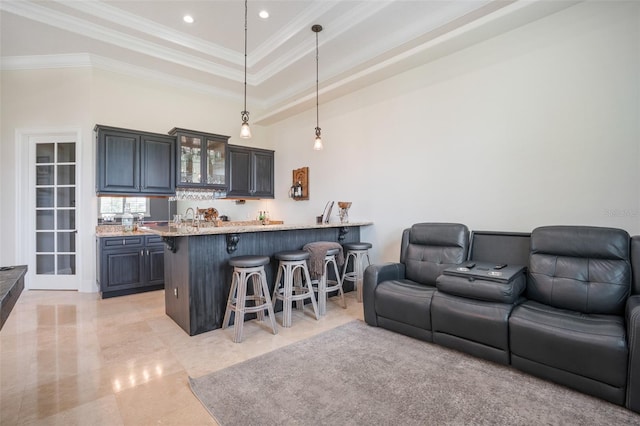 9905 Lanai View Ct, Windermere, FL 34786 - kitchen with a kitchen bar, open floor plan, glass insert cabinets, a peninsula, and ornamental molding