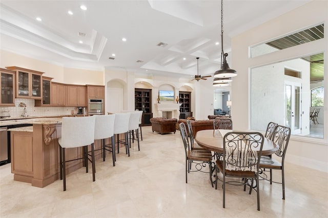 9905 Lanai View Ct, Windermere, FL 34786 - dining space featuring a fireplace, a ceiling fan, recessed lighting, coffered ceiling, and crown molding