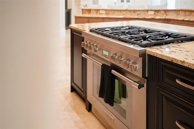 9905 Lanai View Ct, Windermere, FL 34786 - kitchen featuring stainless steel stove, light stone counters, and dark cabinetry
