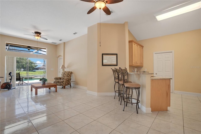 746 Stonewyk Way, Kissimmee, FL 34744 - kitchen with ceiling fan, light brown cabinetry, open floor plan, a peninsula, and a breakfast bar area