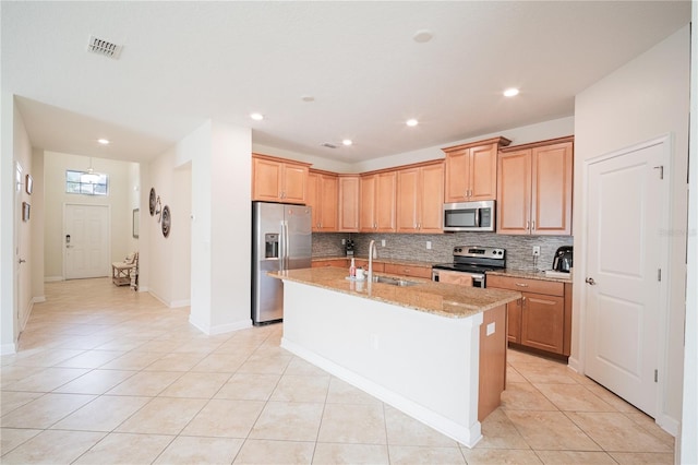 4928 Cortland Dr, Davenport, FL 33837 - kitchen featuring stainless steel appliances, decorative backsplash, an island with sink, light tile patterned floors, and light stone counters