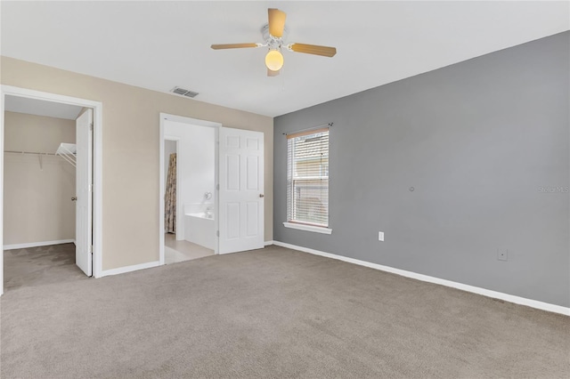 107 Whitehall Way, Kissimmee, FL 34758 - unfurnished bedroom featuring carpet flooring, a walk in closet, a closet, a ceiling fan, and ensuite bathroom