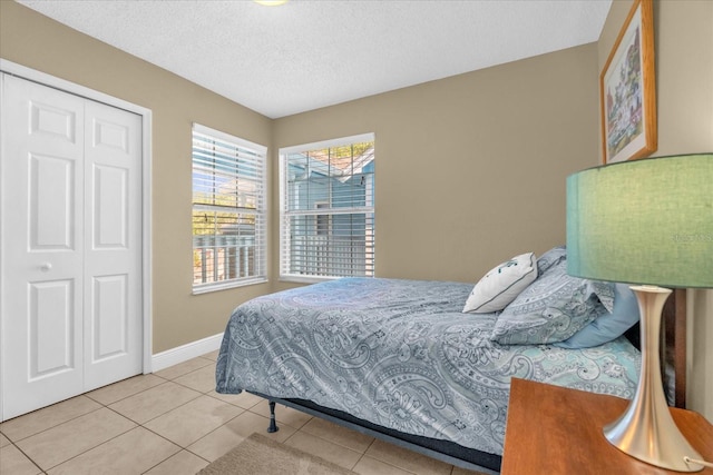 2737 N Poinciana Blvd Unit 92, Kissimmee, FL 34746 - bedroom featuring a textured ceiling, tile patterned flooring, and a closet