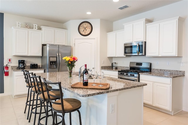 5231 Wildwood Way, Davenport, FL 33837 - kitchen featuring stainless steel appliances, light tile patterned flooring, an island with sink, recessed lighting, and white cabinets