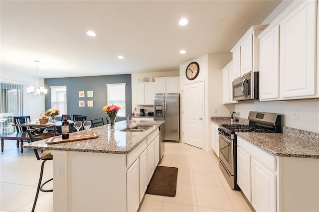 5231 Wildwood Way, Davenport, FL 33837 - kitchen featuring appliances with stainless steel finishes, recessed lighting, white cabinets, a chandelier, and a kitchen breakfast bar