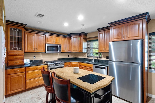 878 Elgin Dr, Winter Springs, FL 32708 - kitchen with appliances with stainless steel finishes, a textured ceiling, brown cabinets, glass insert cabinets, and recessed lighting