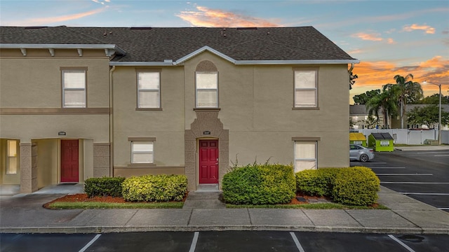 2867 Club Cortile Cir, Kissimmee, FL 34746 - view of property with uncovered parking, stucco siding, and a shingled roof