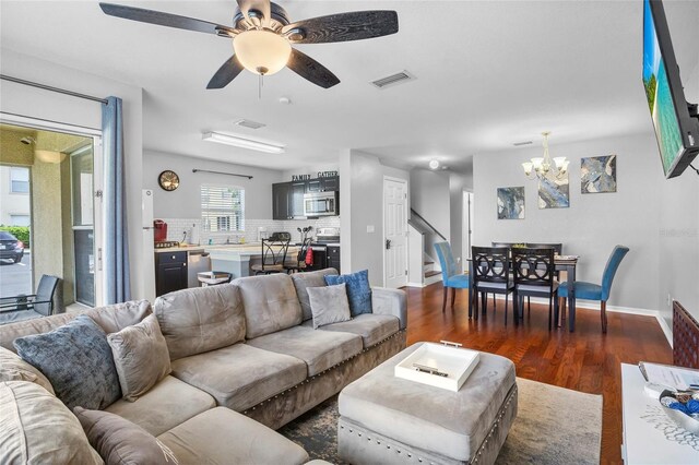 2867 Club Cortile Cir, Kissimmee, FL 34746 - living room featuring a chandelier, dark wood-style flooring, ceiling fan, and stairs