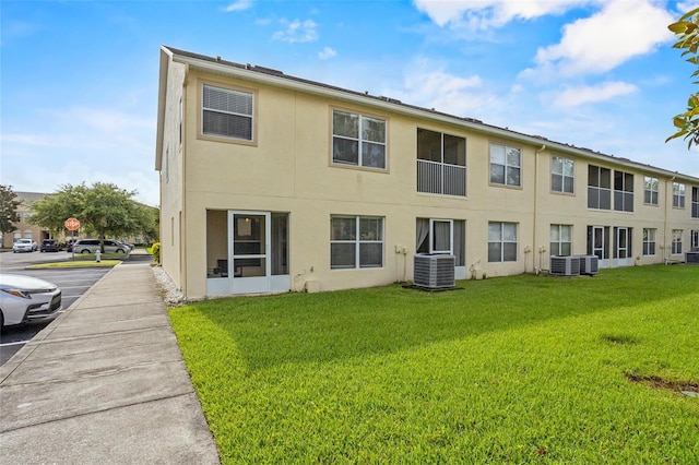 2867 Club Cortile Cir, Kissimmee, FL 34746 - back of house with stucco siding and a lawn