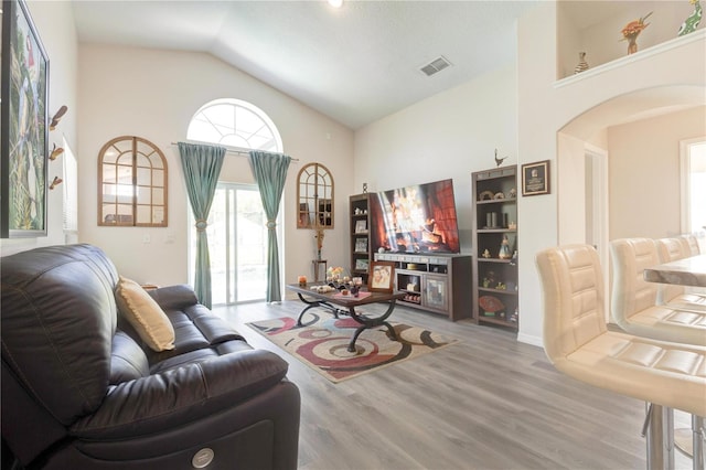 1014 Prey Ct, Kissimmee, FL 34746 - living room featuring arched walkways, wood finished floors, and high vaulted ceiling