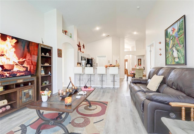 1014 Prey Ct, Kissimmee, FL 34746 - living area with arched walkways, light wood-type flooring, and high vaulted ceiling
