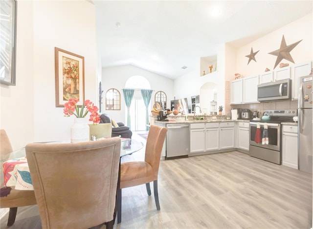 1014 Prey Ct, Kissimmee, FL 34746 - dining space featuring light wood-style flooring and vaulted ceiling