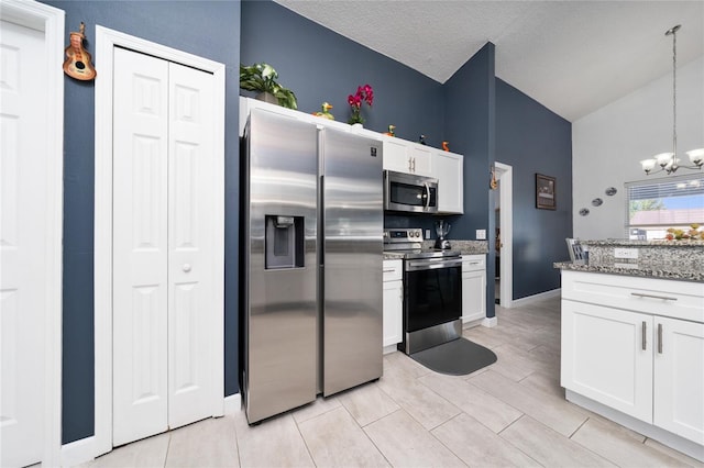 5100 Violet Ln, Kissimmee, FL 34758 - kitchen with stainless steel appliances, a chandelier, white cabinets, light stone counters, and hanging light fixtures