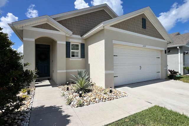 2727 Harmonia Hammock Rd, Harmony, FL 34773 - view of front of property featuring stucco siding, a garage, and concrete driveway
