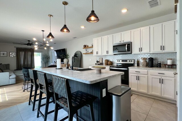 2727 Harmonia Hammock Rd, Harmony, FL 34773 - kitchen featuring stainless steel appliances, decorative backsplash, light countertops, open floor plan, and a kitchen bar