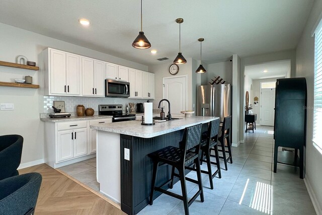 2727 Harmonia Hammock Rd, Harmony, FL 34773 - kitchen with stainless steel appliances, light countertops, tasteful backsplash, a breakfast bar, and open shelves