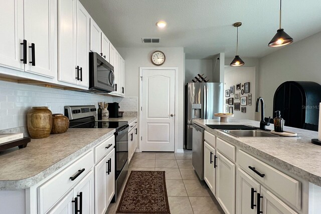 2727 Harmonia Hammock Rd, Harmony, FL 34773 - kitchen featuring appliances with stainless steel finishes, backsplash, pendant lighting, light tile patterned flooring, and light countertops