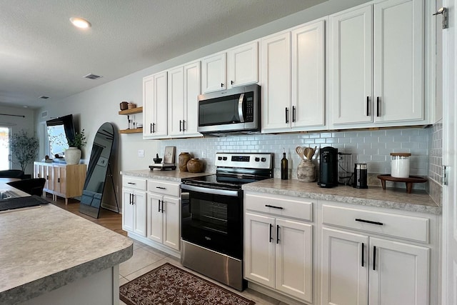 2727 Harmonia Hammock Rd, Harmony, FL 34773 - kitchen with appliances with stainless steel finishes, tasteful backsplash, white cabinets, open shelves, and light countertops