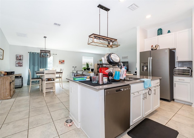 1959 Cricket Cradle Dr, Kissimmee, FL 34746 - kitchen with appliances with stainless steel finishes, light tile patterned floors, a kitchen island with sink, and white cabinetry