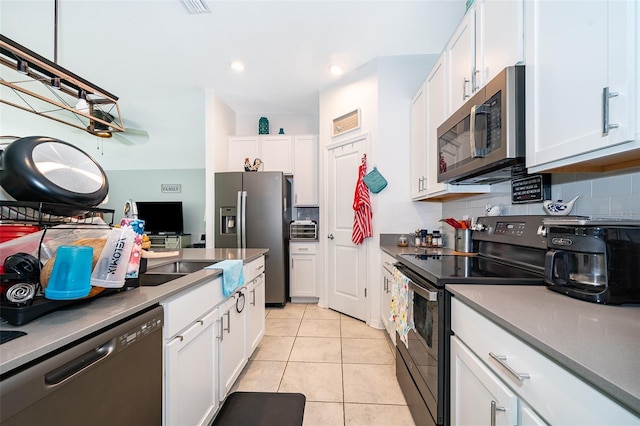 1959 Cricket Cradle Dr, Kissimmee, FL 34746 - kitchen with appliances with stainless steel finishes, white cabinets, tasteful backsplash, and light tile patterned floors
